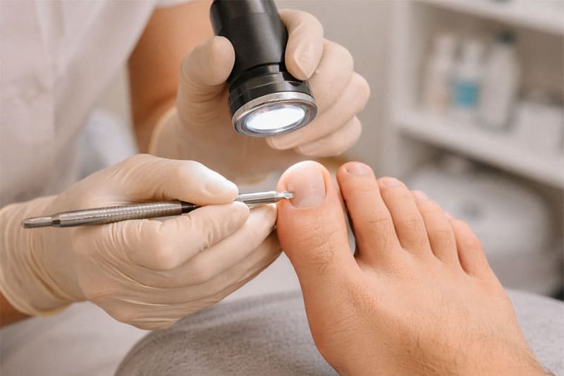 Podóloga Josy realizando avaliação técnica detalhada na lâmina ungueal de um paciente em consultório. Podóloga Josy realizando avaliação técnica detalhada na lâmina ungueal de um paciente em consultório.